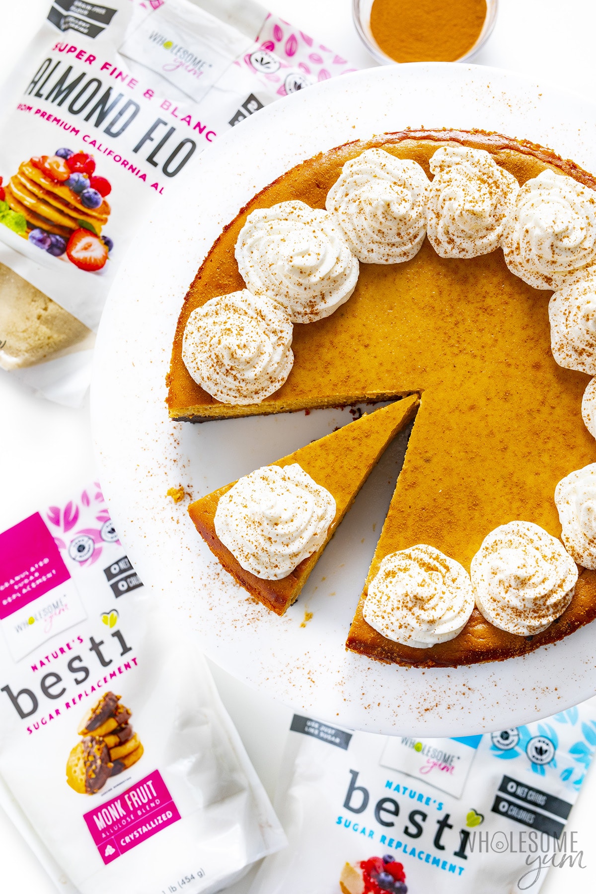 Next to the Keto Pumpkin Cheesecake is a bag of Besti and Wholesome Yum almond flour.