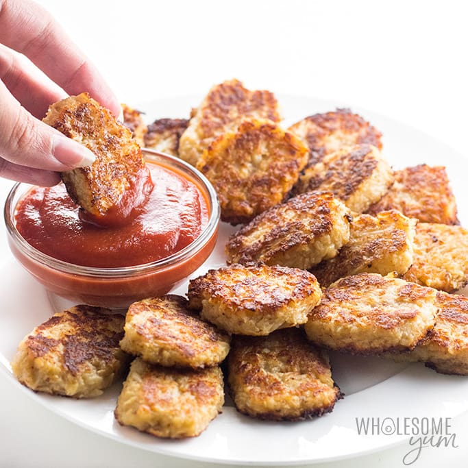 Cheesy low carb cauliflower tots on a plate with dippping sauce