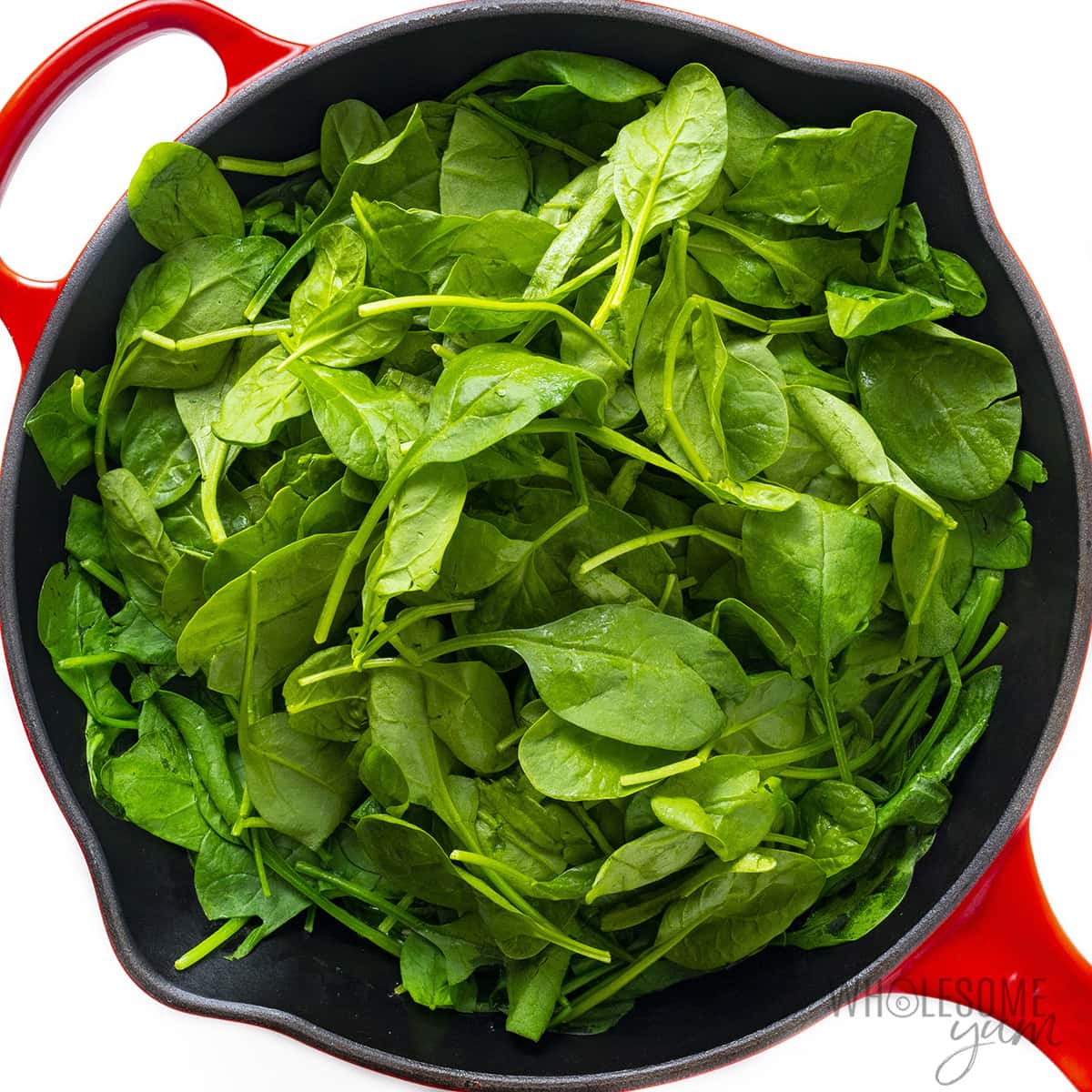 Fresh spinach leaves added to the skillet.