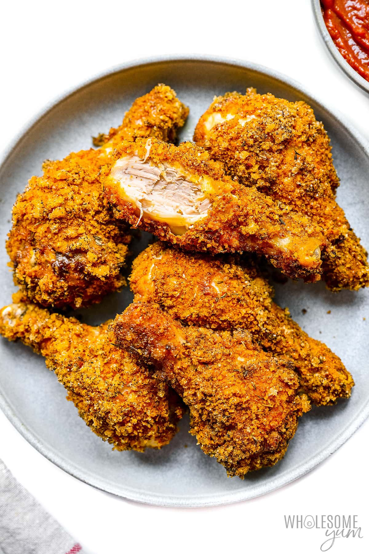 Low carb fried chicken with a bite out of one leg.