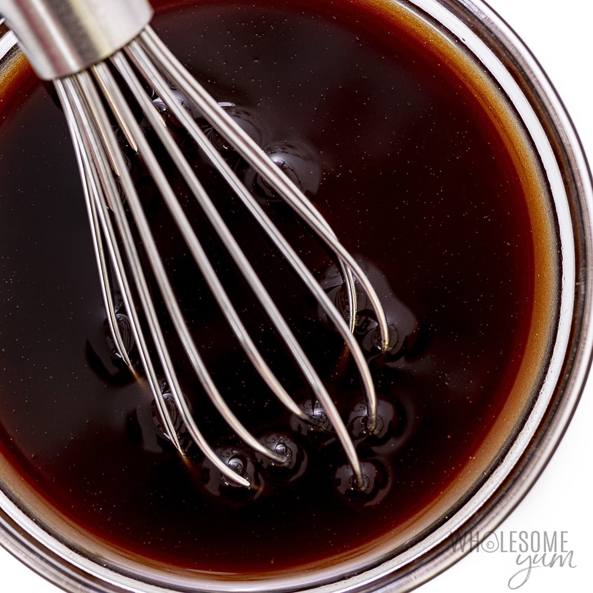 Oil and vinegar whisked together in a bowl.