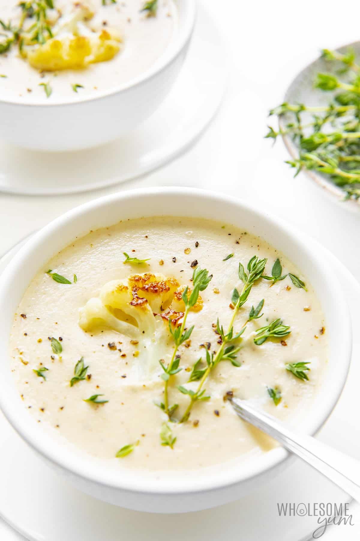 Roasted cauliflower soup with fresh thyme leaves.