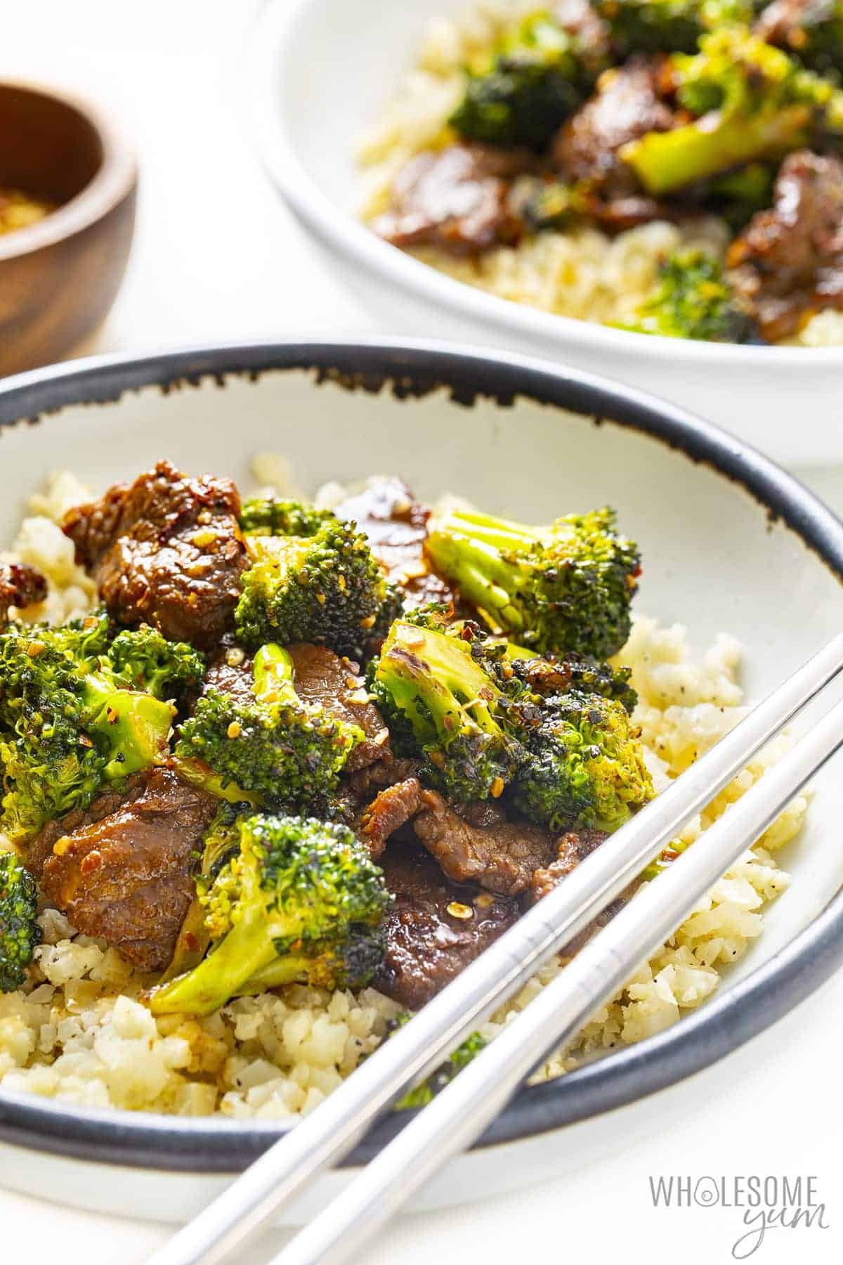 Bowl of low carb beef and broccoli over cauliflower rice.