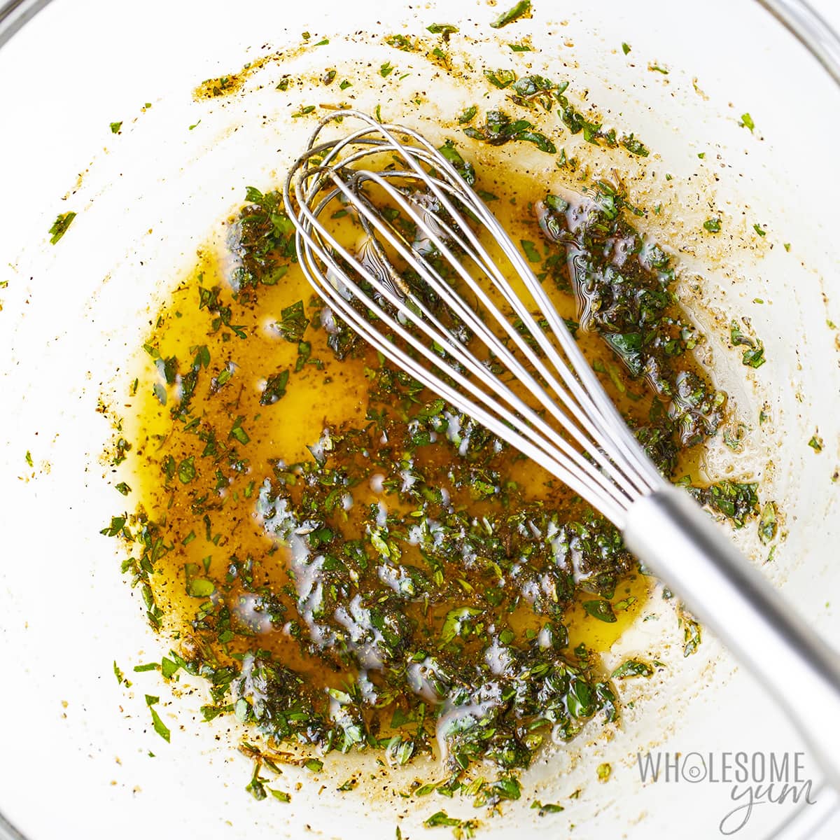 Marinade mixed in a glass bowl with whisk.