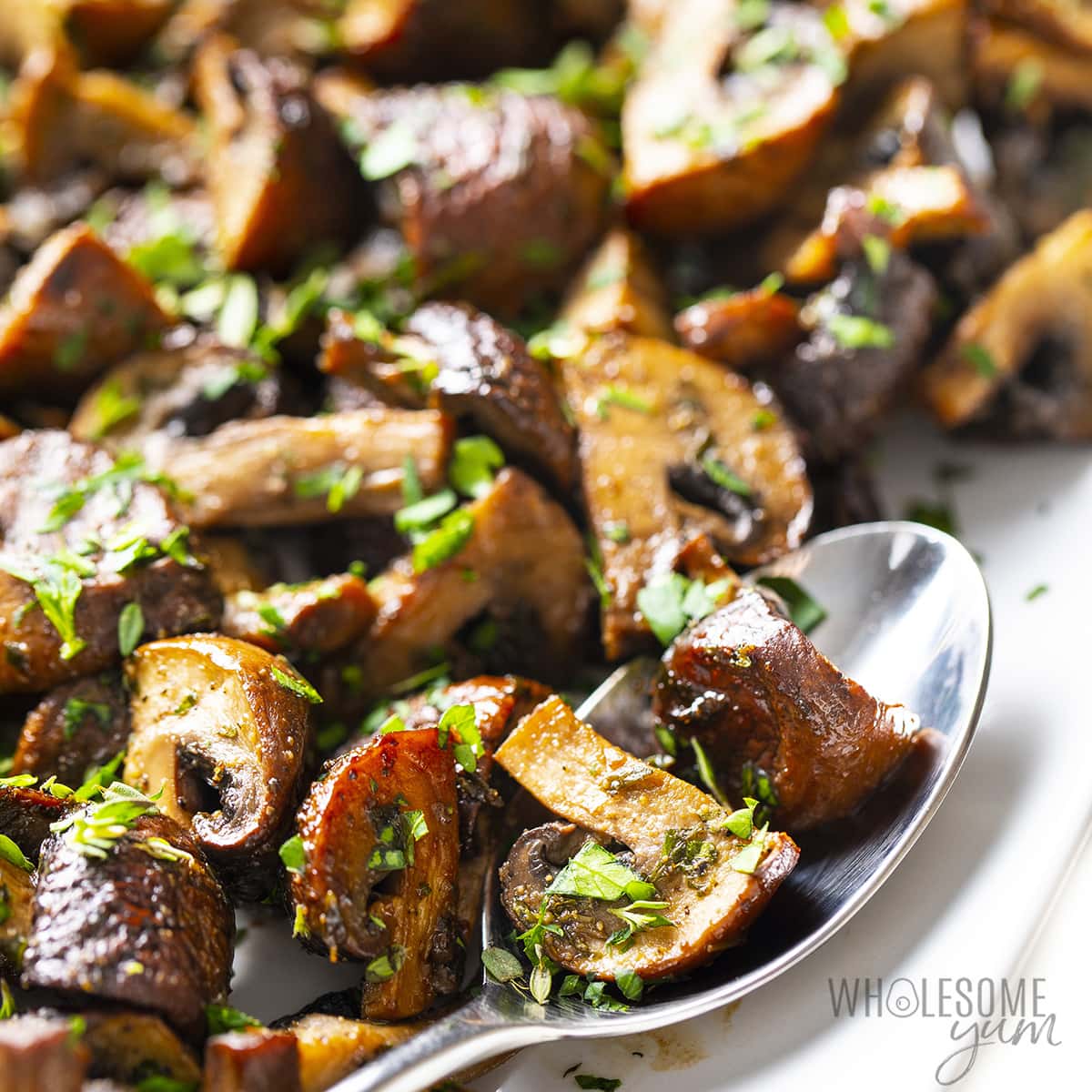 Oven roasted mushrooms with balsamic with spoon.