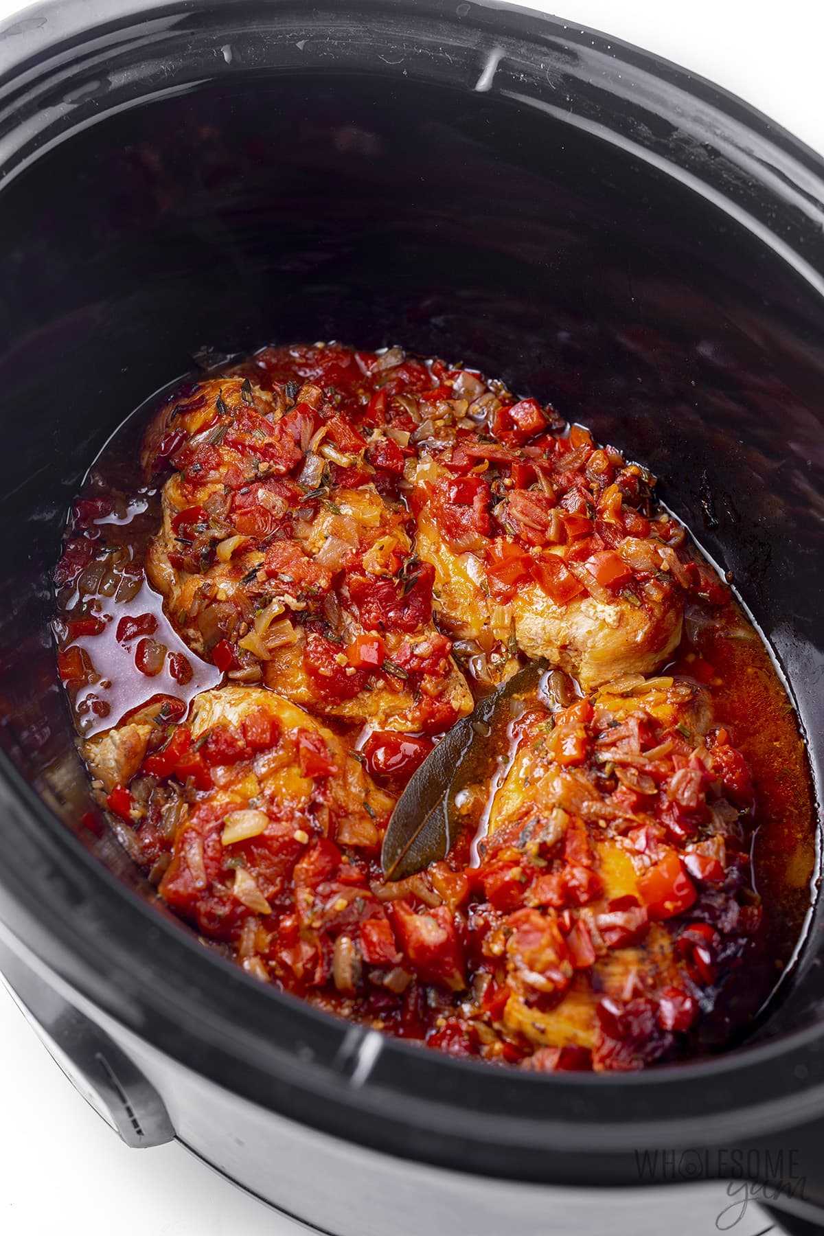 Chicken cacciatore in the Crock Pot with bay leaf.