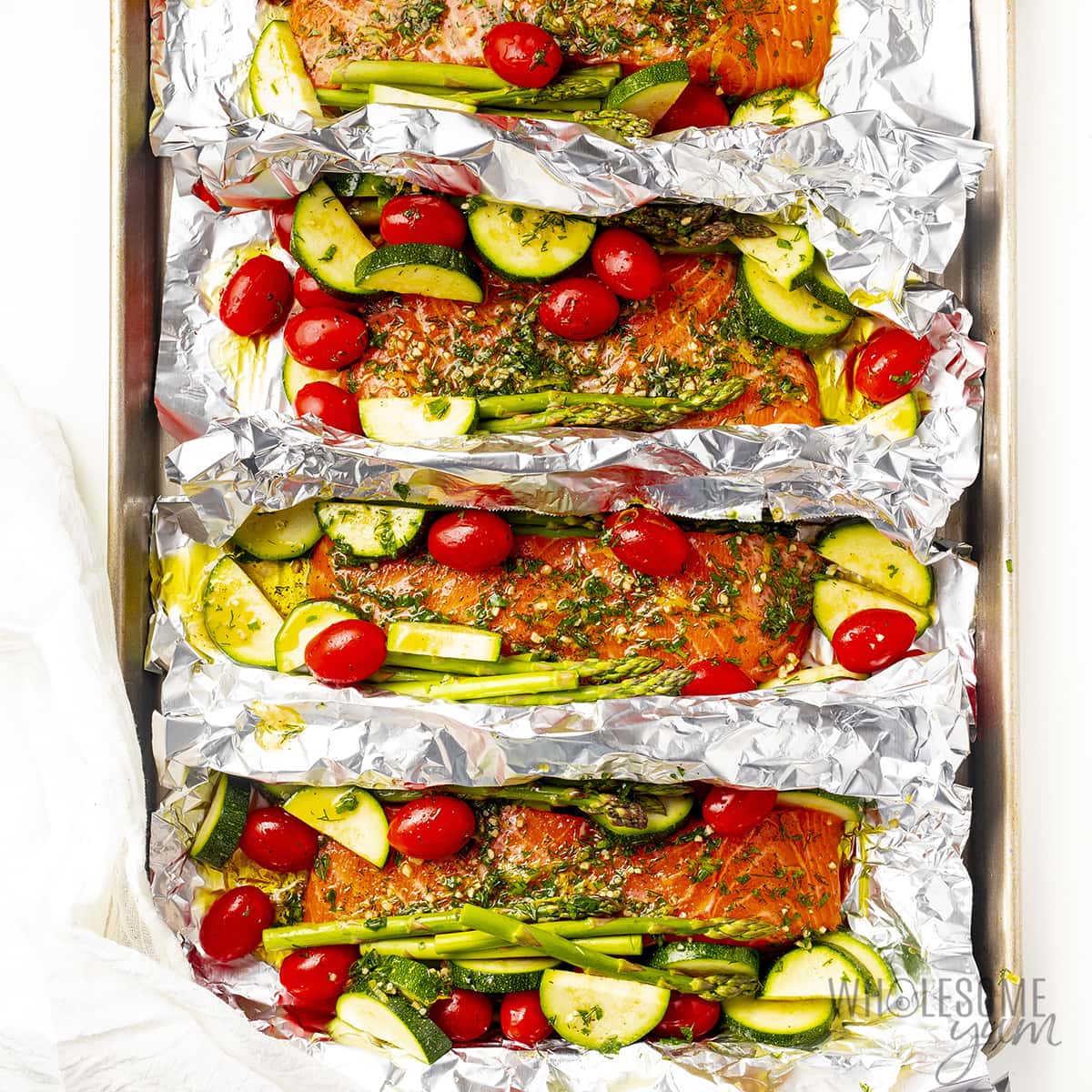 Seasoned raw salmon and vegetables in foil.
