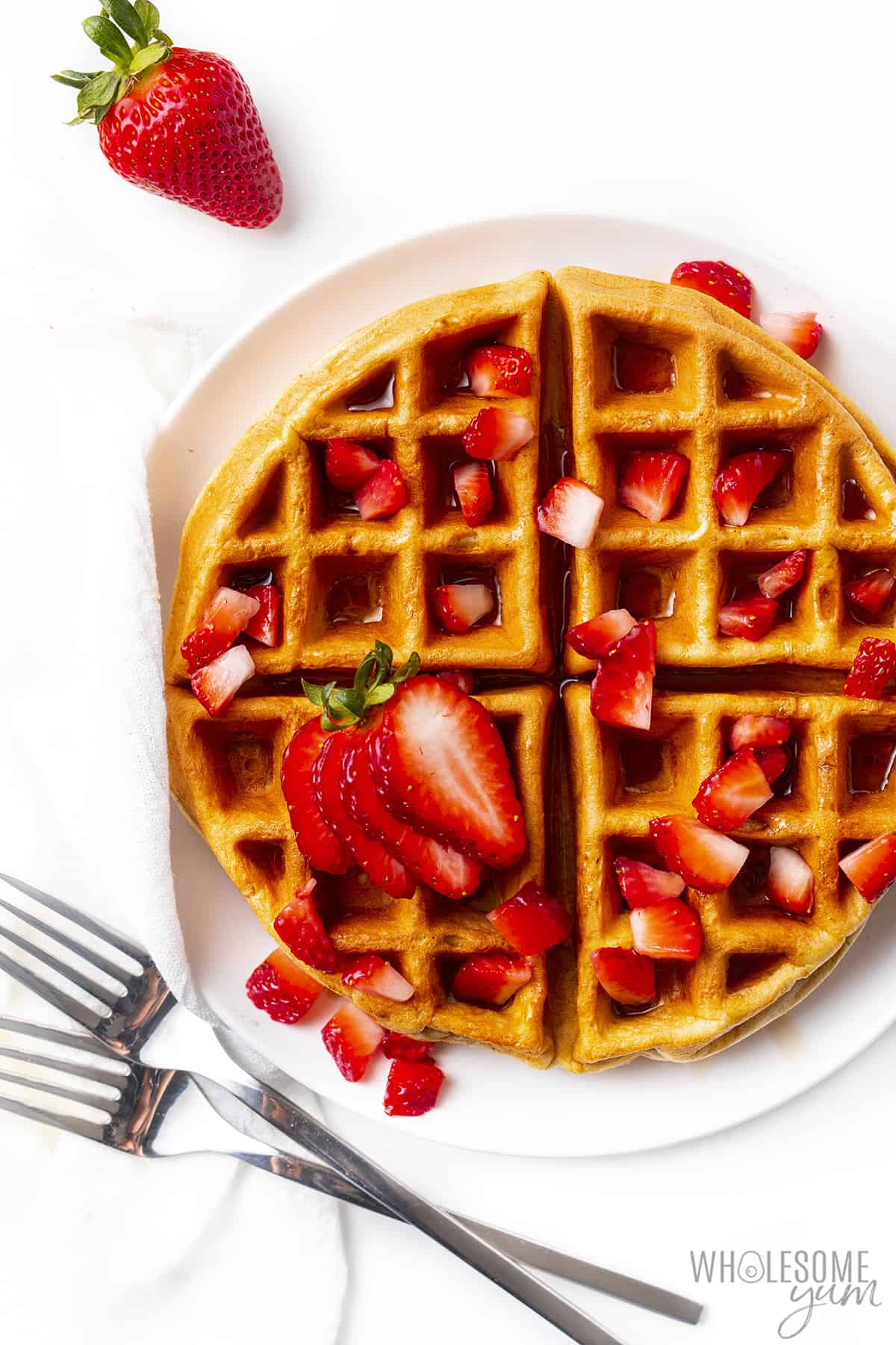 Protein waffles with strawberries and forks.