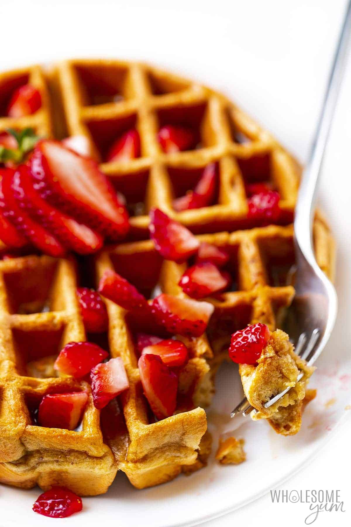Close up of waffle with bite on a fork.