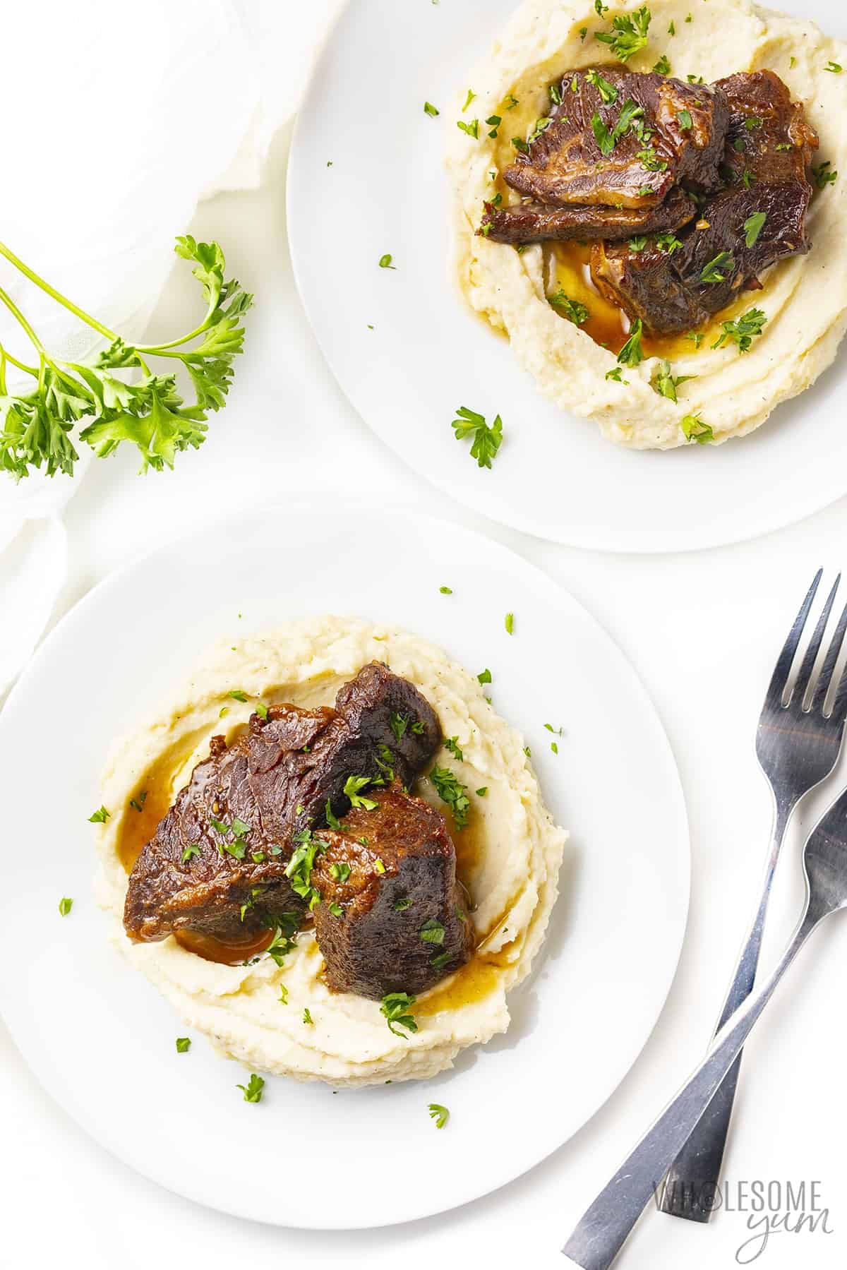 Plate with boneless beef short ribs over mashed cauliflower.