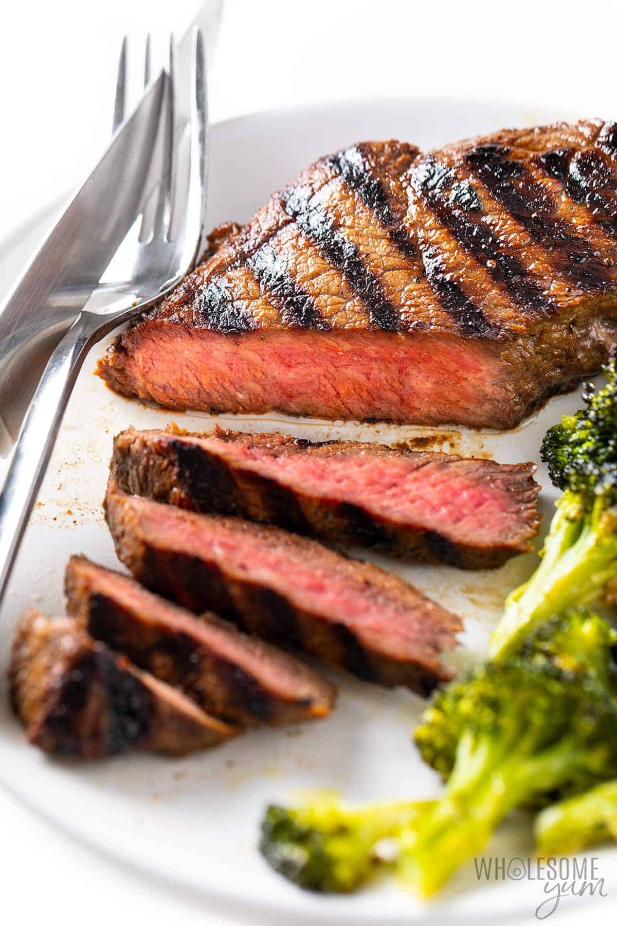 Sliced top sirloin steak recipe on a plate with broccoli.