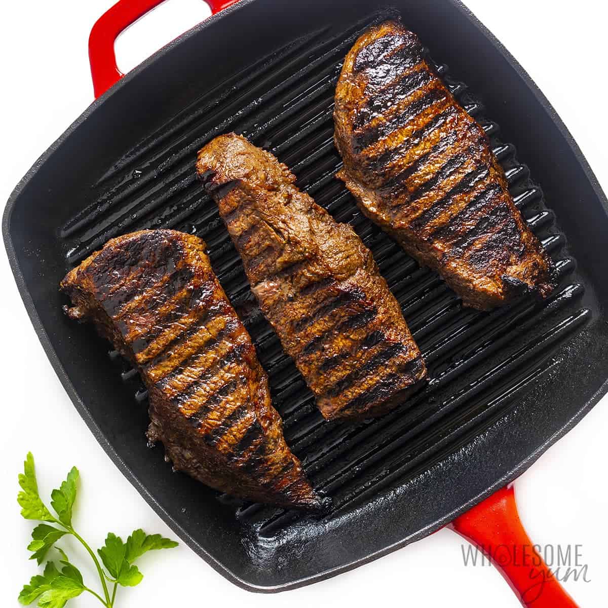 Perfect sirloin steaks in cast iron pan.