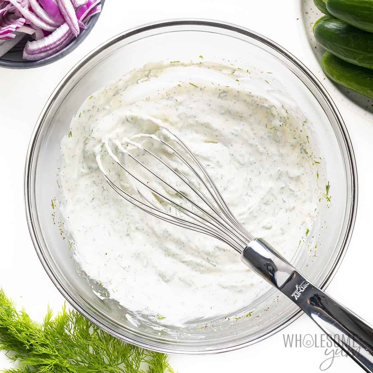 Salad dressing in a bowl with whisk.