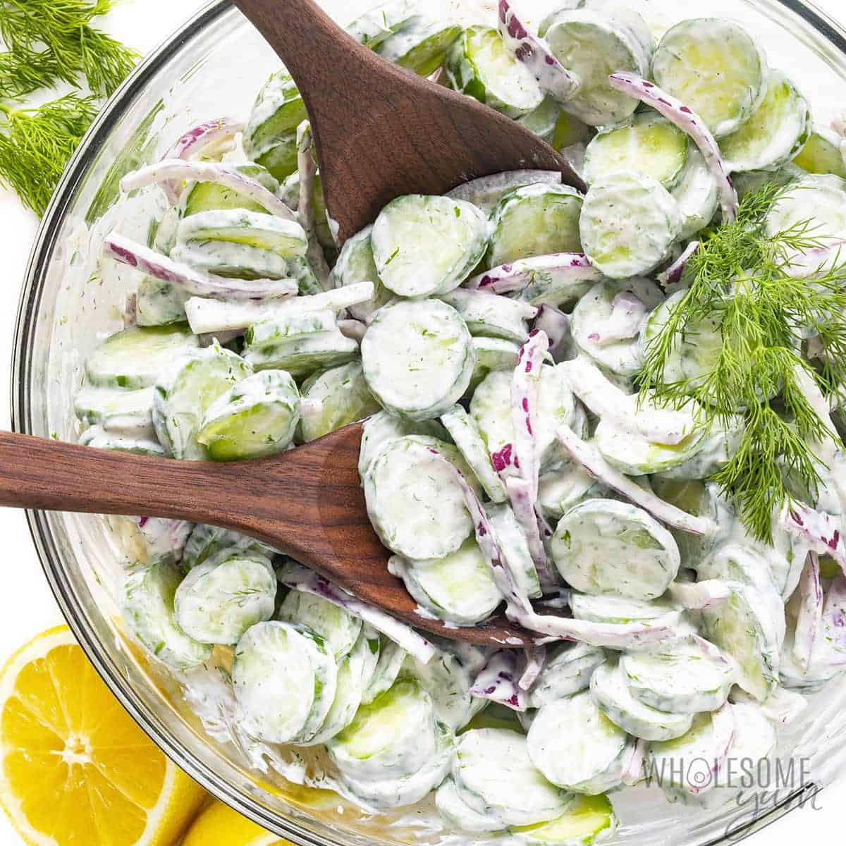 Creamy cucumber salad recipe with sour cream and dill, in a bowl.