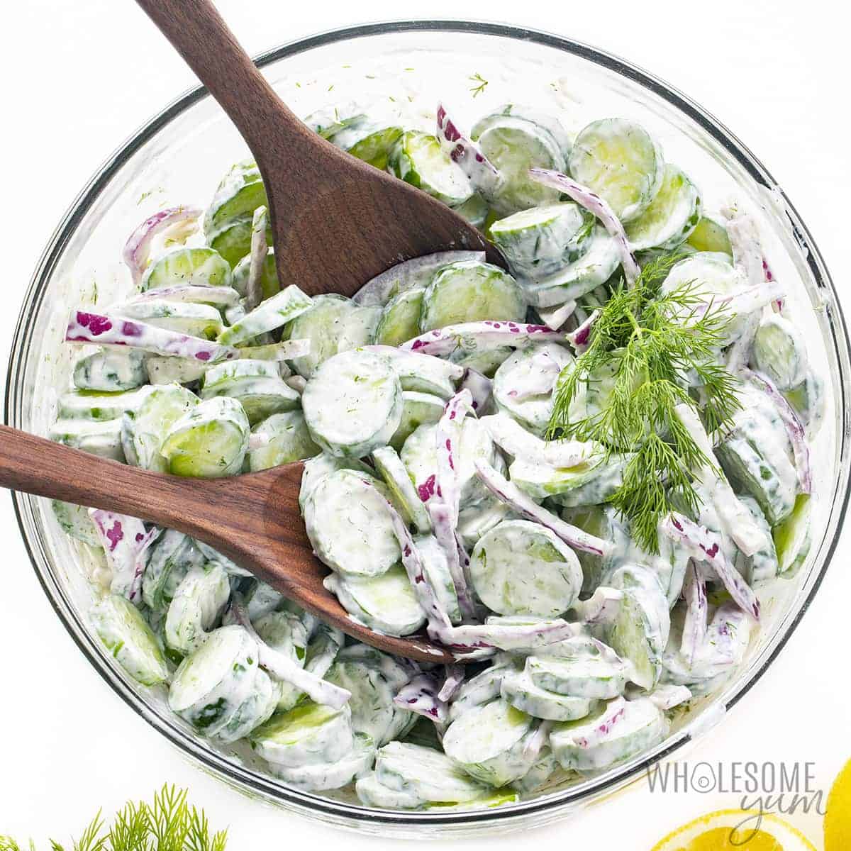 Sour cream cucumber salad tossed in a bowl.