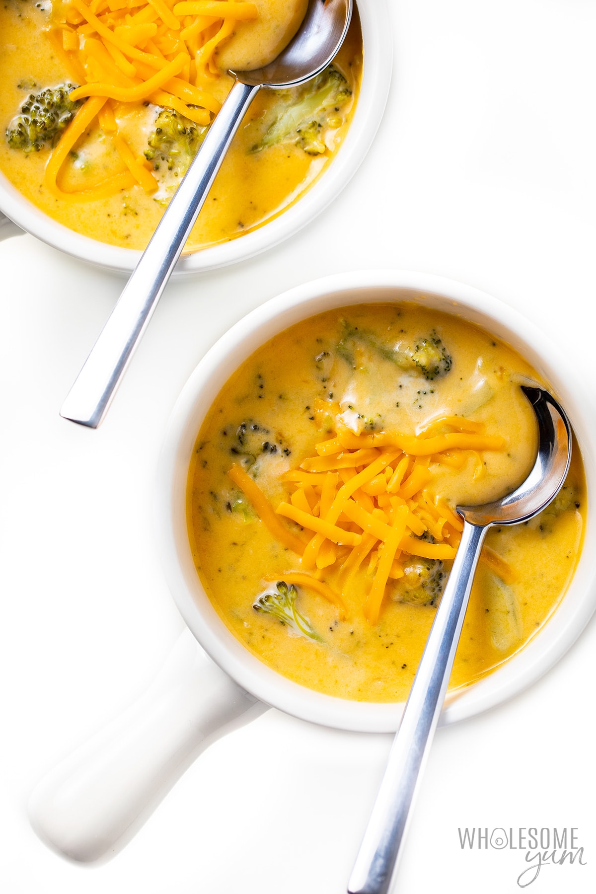 Two bowls of broccoli and cheese soup.