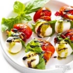 Caprese salad skewers recipe on a plate with fresh basil.