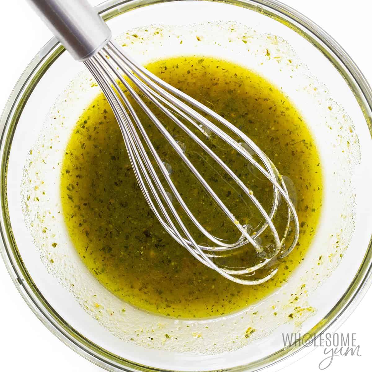 Pesto for caprese salad skewers whisked in a bowl.