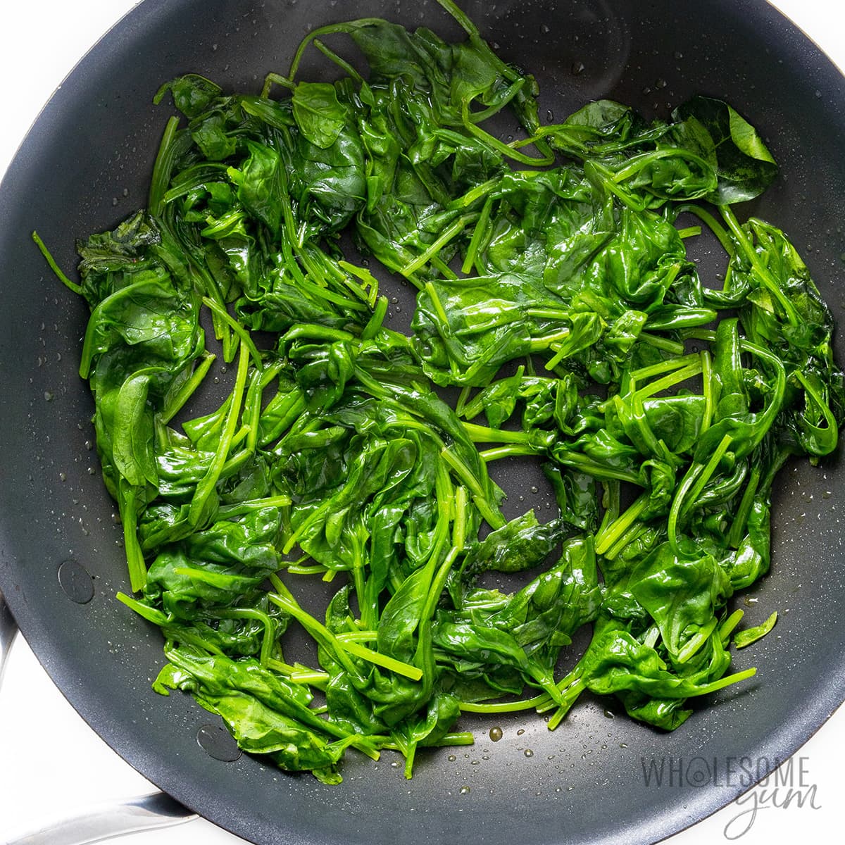 Spinach wilted in a skillet.