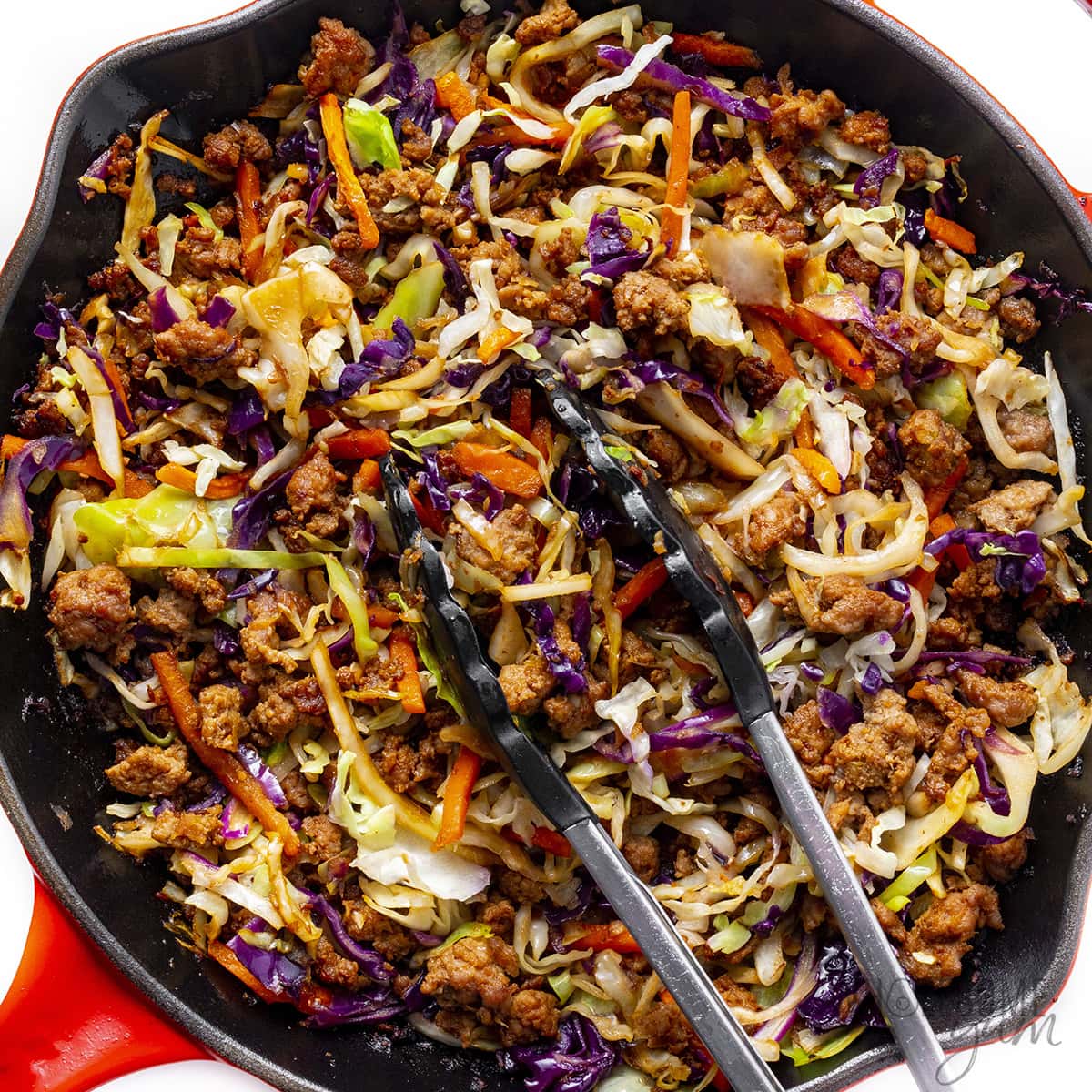 Coleslaw mix and coconut aminos added to the skillet and sauteed.