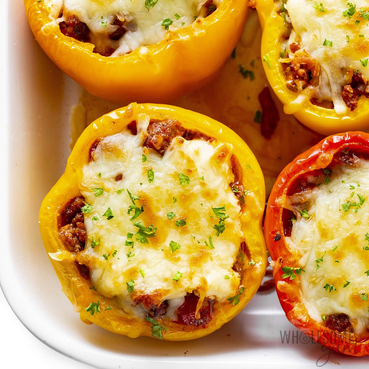 Fully cooked tomato stuffed bell peppers, garnished with parsley.
