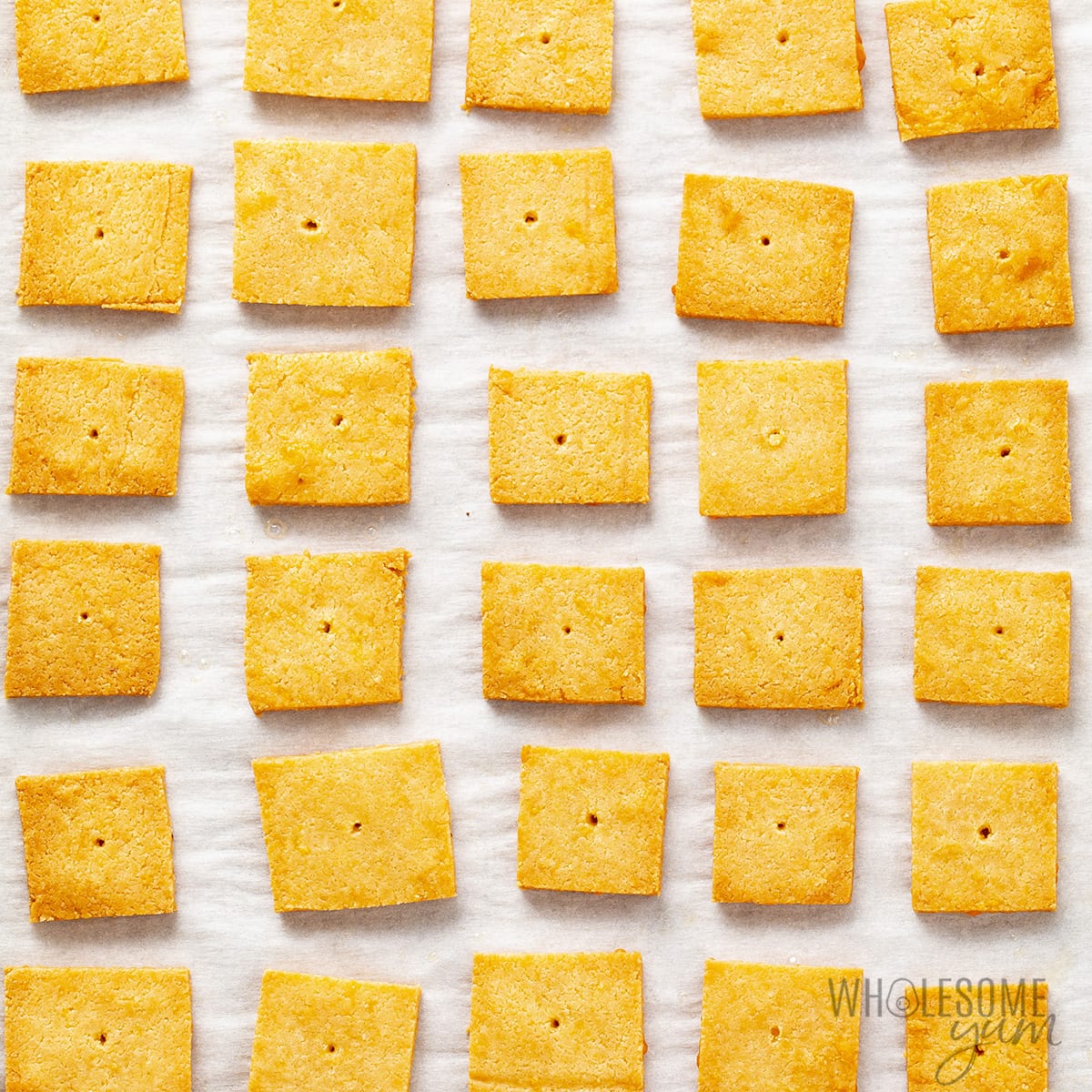 Baked cheese crackers on parchment paper.