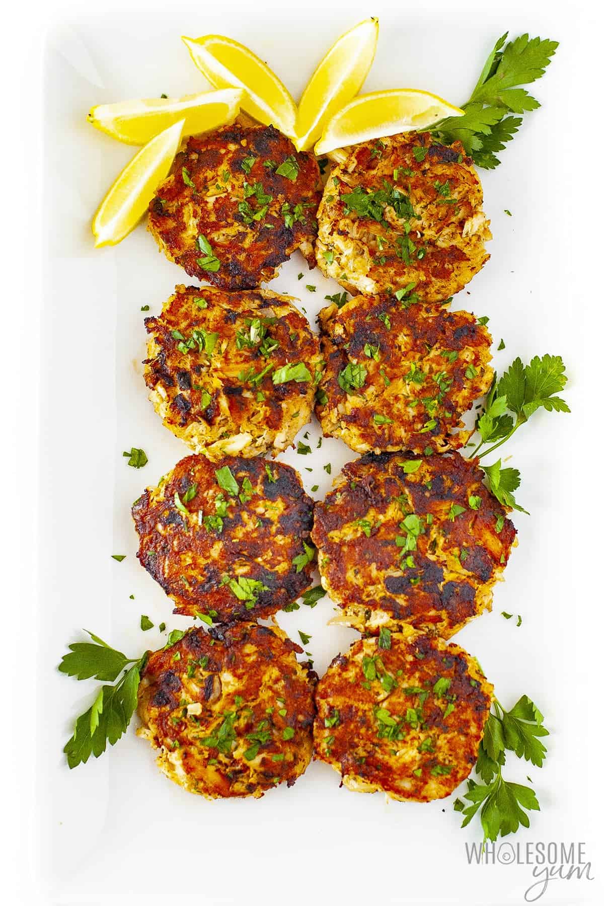 Gluten free crab cakes in two rows on a platter.
