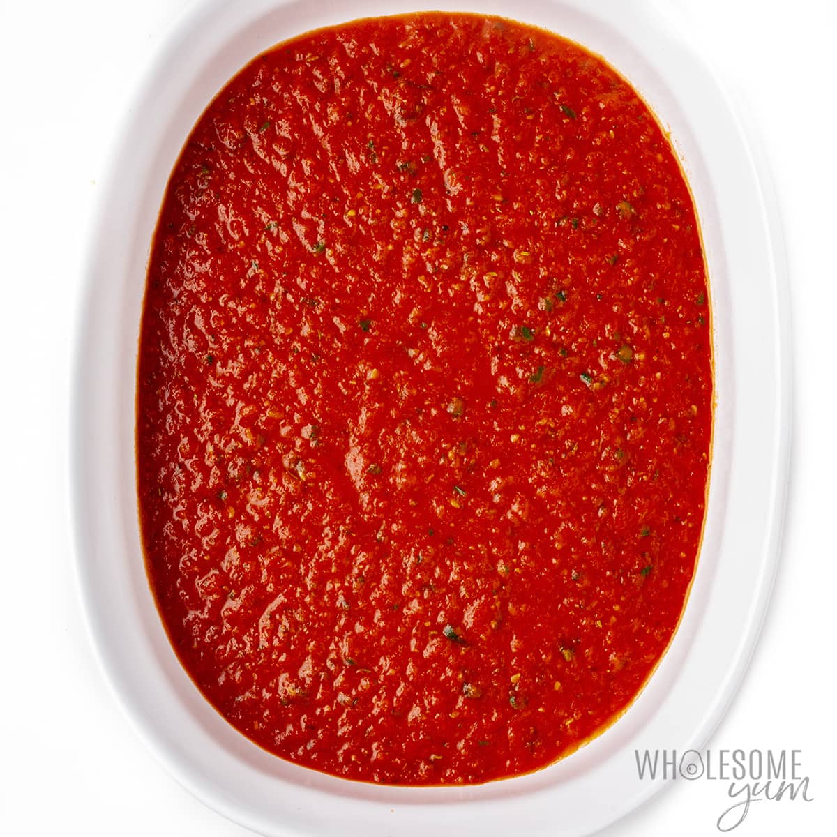 Sauce poured in a thin layer at the bottom of the baking dish.