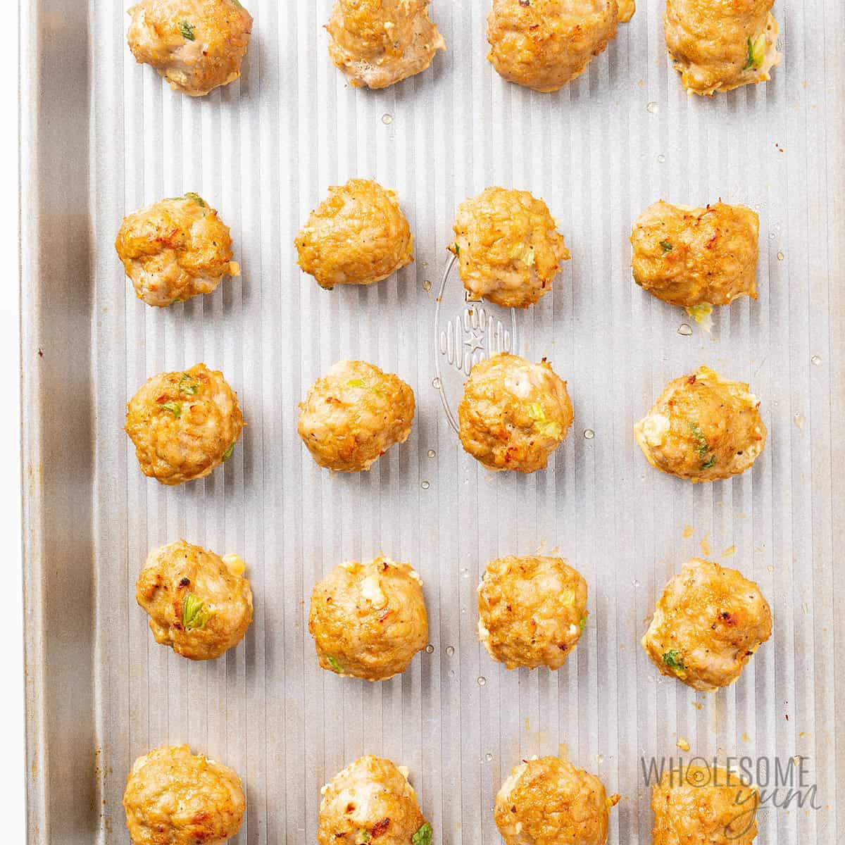 Baked Asian meatballs on a baking sheet.
