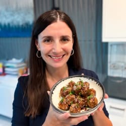 Maya holding a bowl of juicy Asian meatballs.