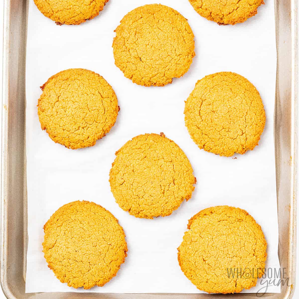 Baked pumpkin cookies with lightly golden edges on a sheet pan.