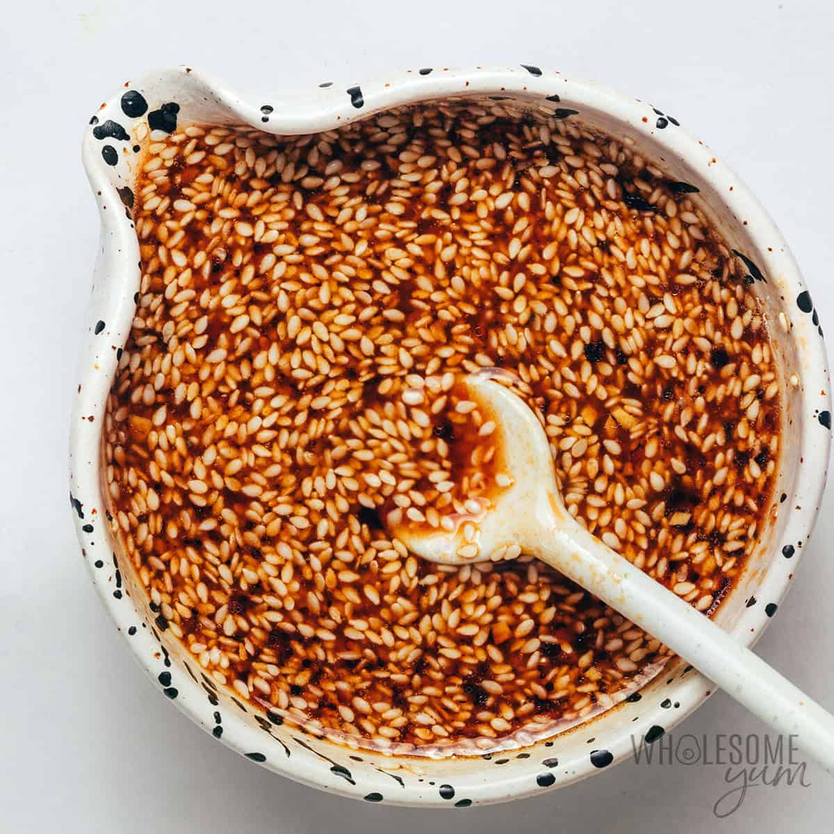 Whisking sauce ingredients together in a bowl.