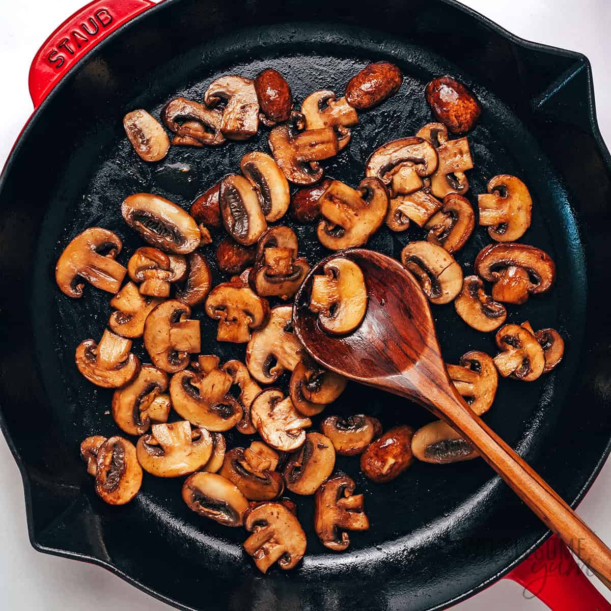Sautéing mushrooms in a cast iron skillet.