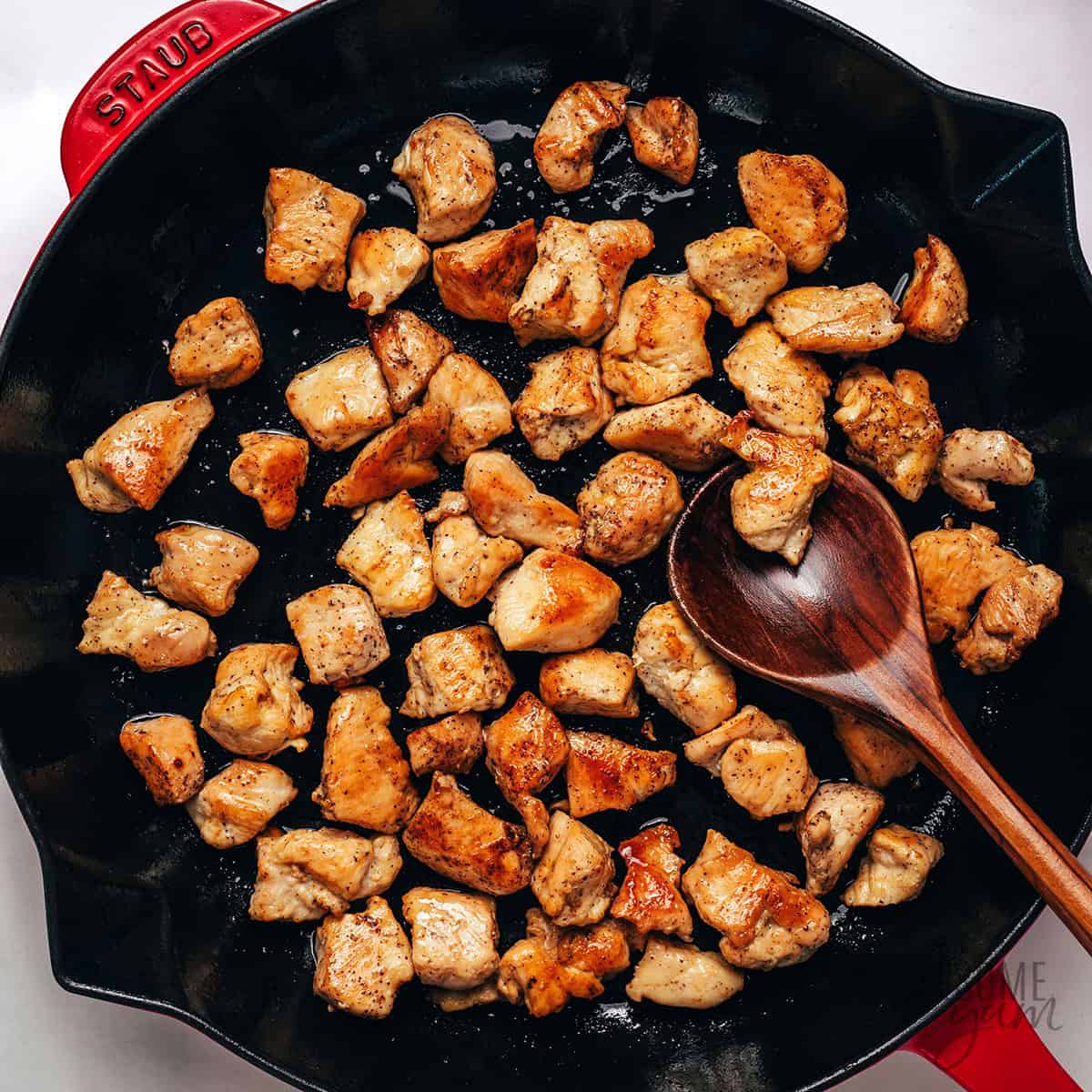 Searing chicken in a cast iron skillet.