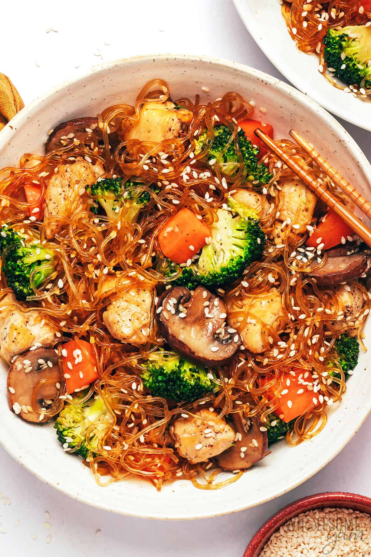Juicy chicken, crisp veggies, and tender kelp noodles in a bowl with chopsticks.