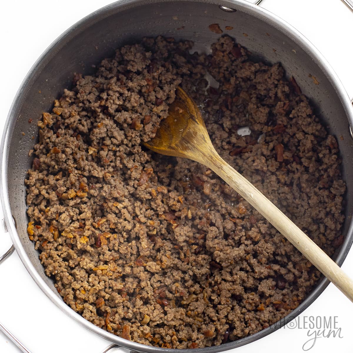 Ground beef browning in pan.