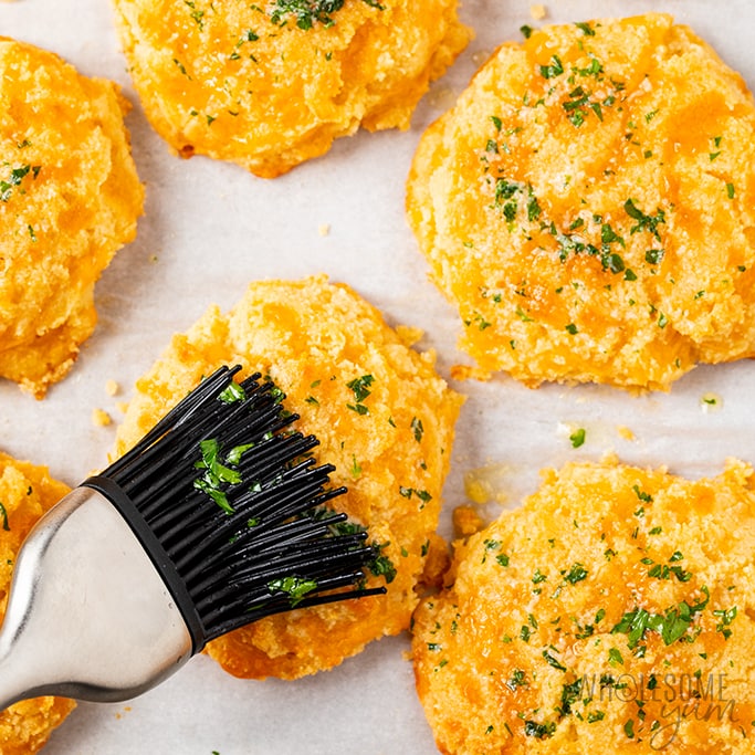 brushing keto biscuits with garlic butter