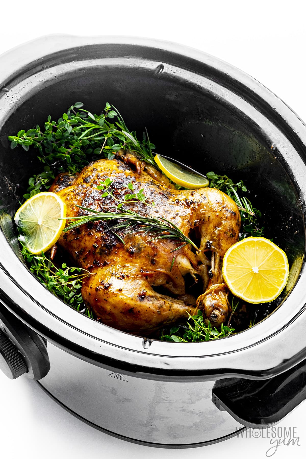 Whole chicken in Crock Pot with herbs and lemon.
