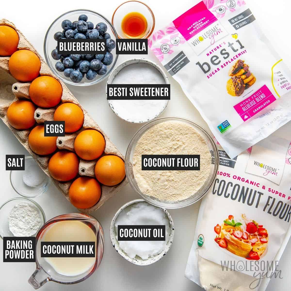 Labeled recipe ingredients: Blueberries, eggs, coconut oil, unsweetened coconut milk beverage, vanilla extract, Wholesome Yum Coconut Flour, Wholesome Yum Granulated Allulose, baking powder, and sea salt.
