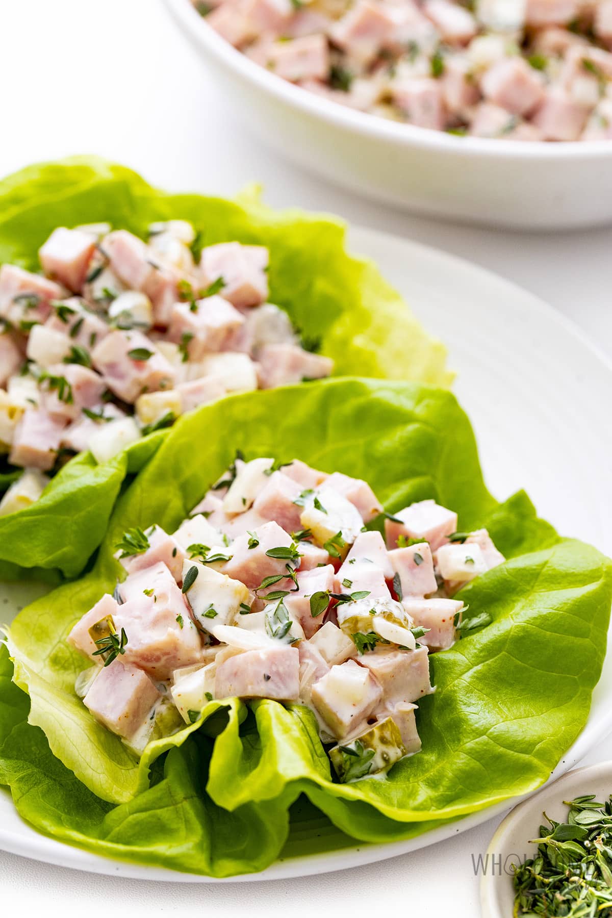 Ham salad in lettuce wraps on a plate.