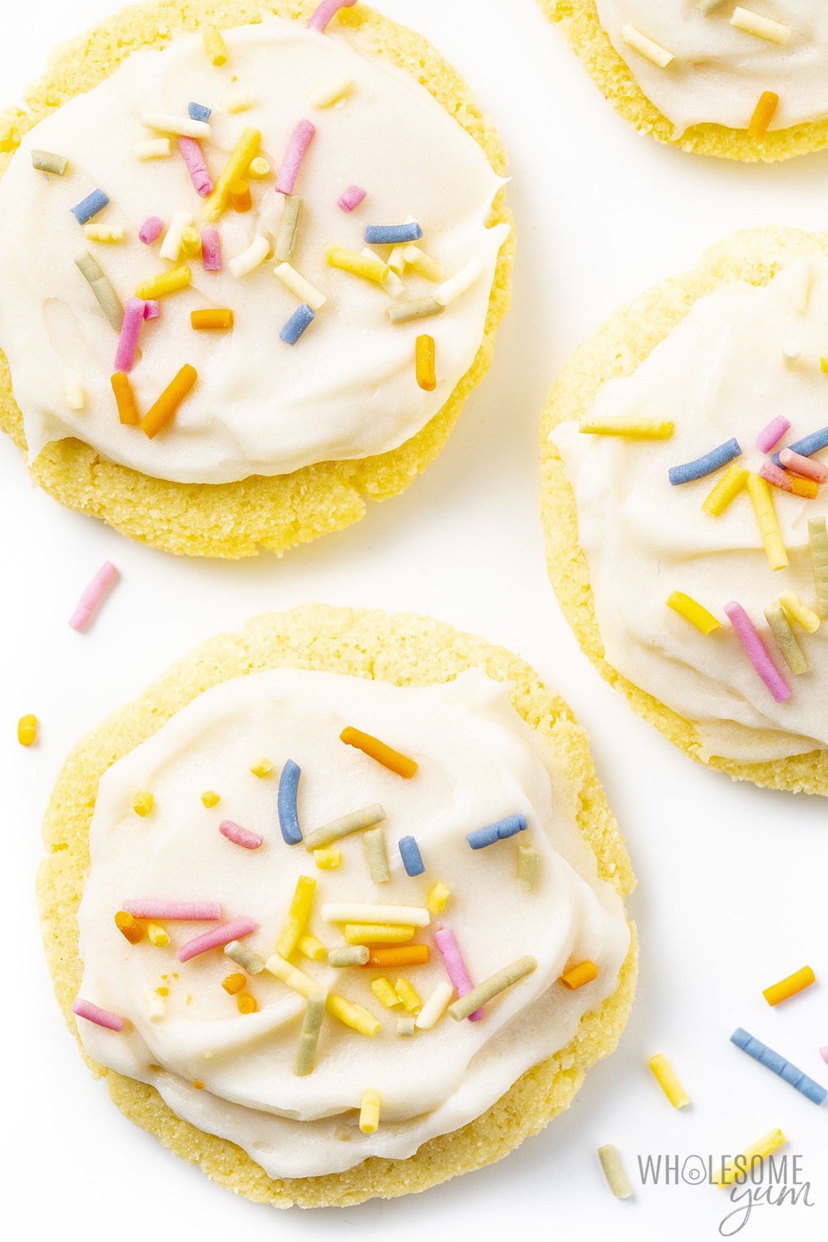 Round keto cookies with frosting and sprinkles.