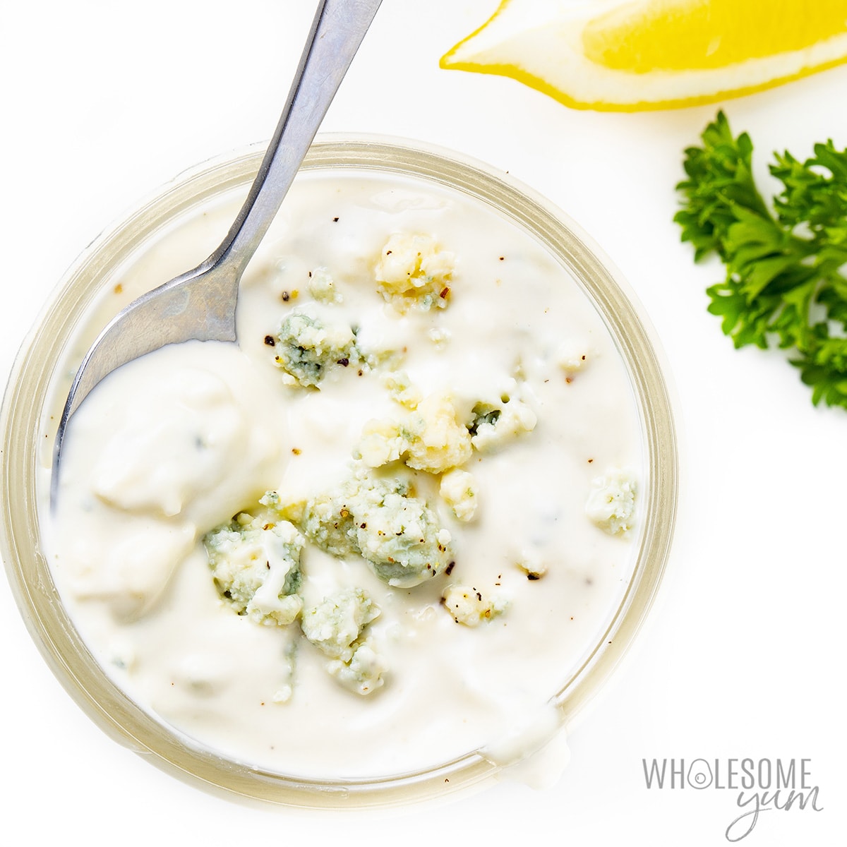 Homemade blue cheese dressing with a spoon in it.