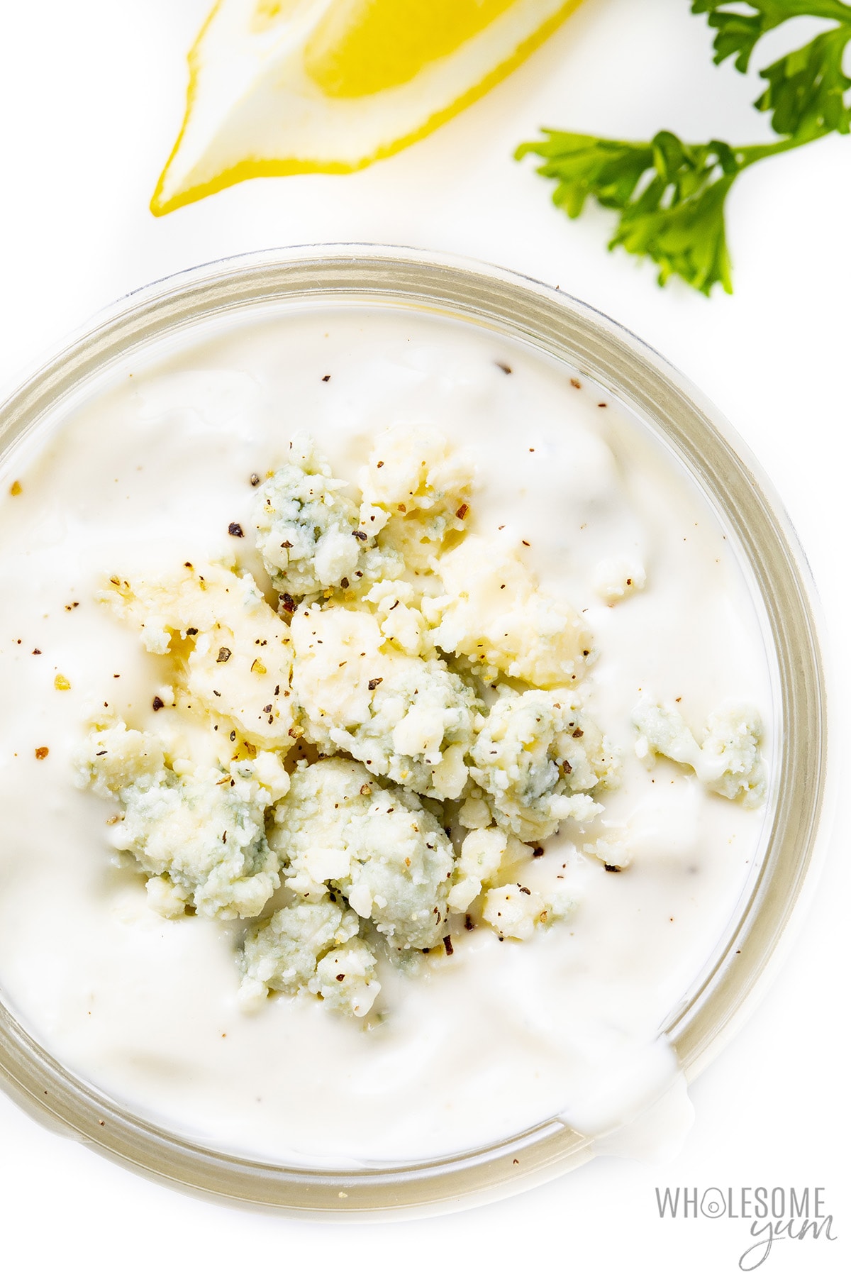 Homemade blue cheese dressing in a jar with crumbles on top.