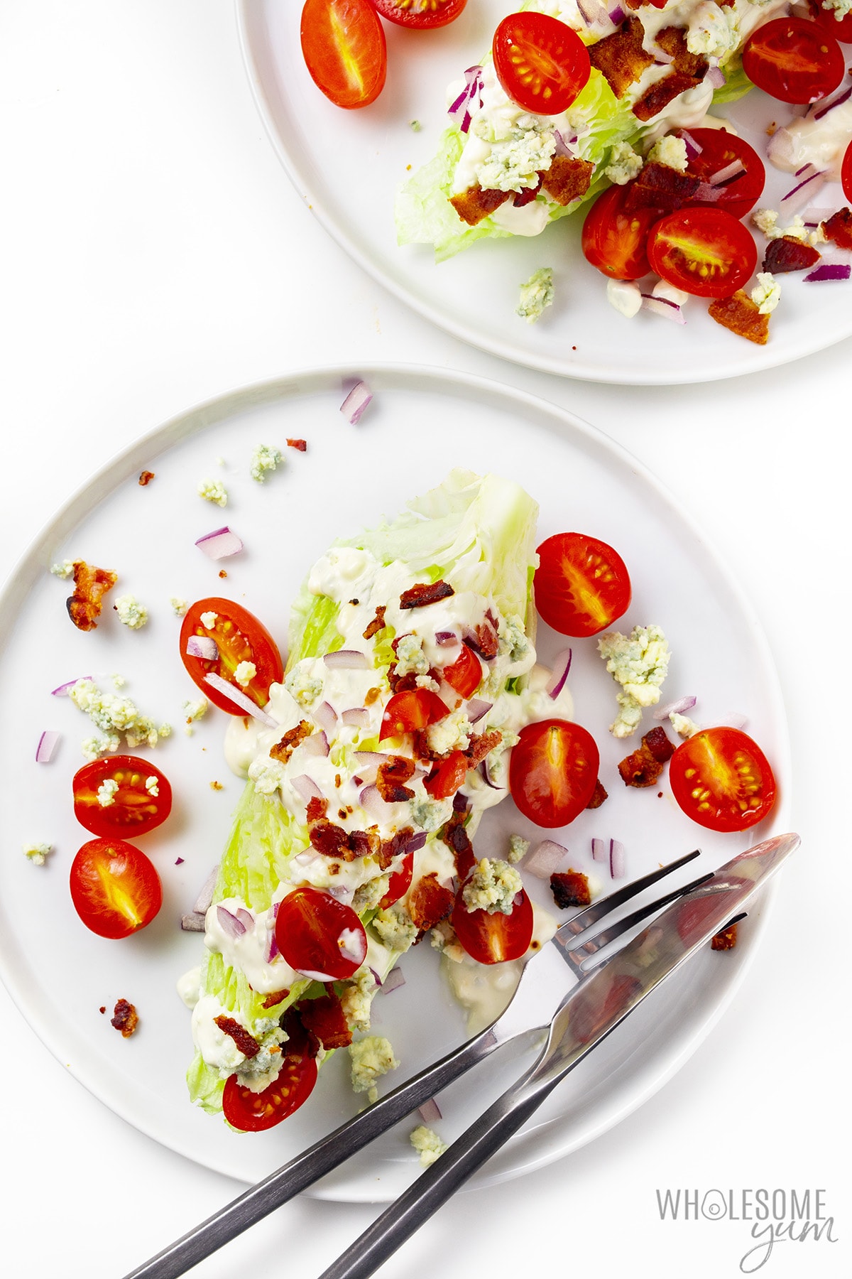Wedge salads on plates with fork and knife.