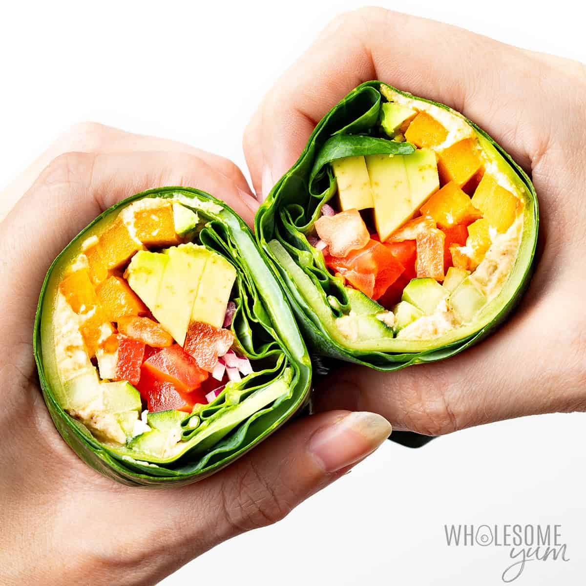 Collard green wraps held in two hands.