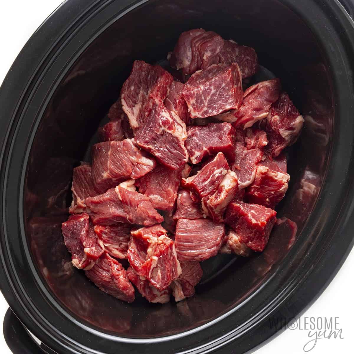 Beef chunks in a slow cooker.