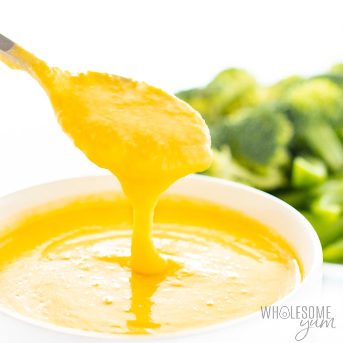 Keto cheese sauce for broccoli coming off a spoon