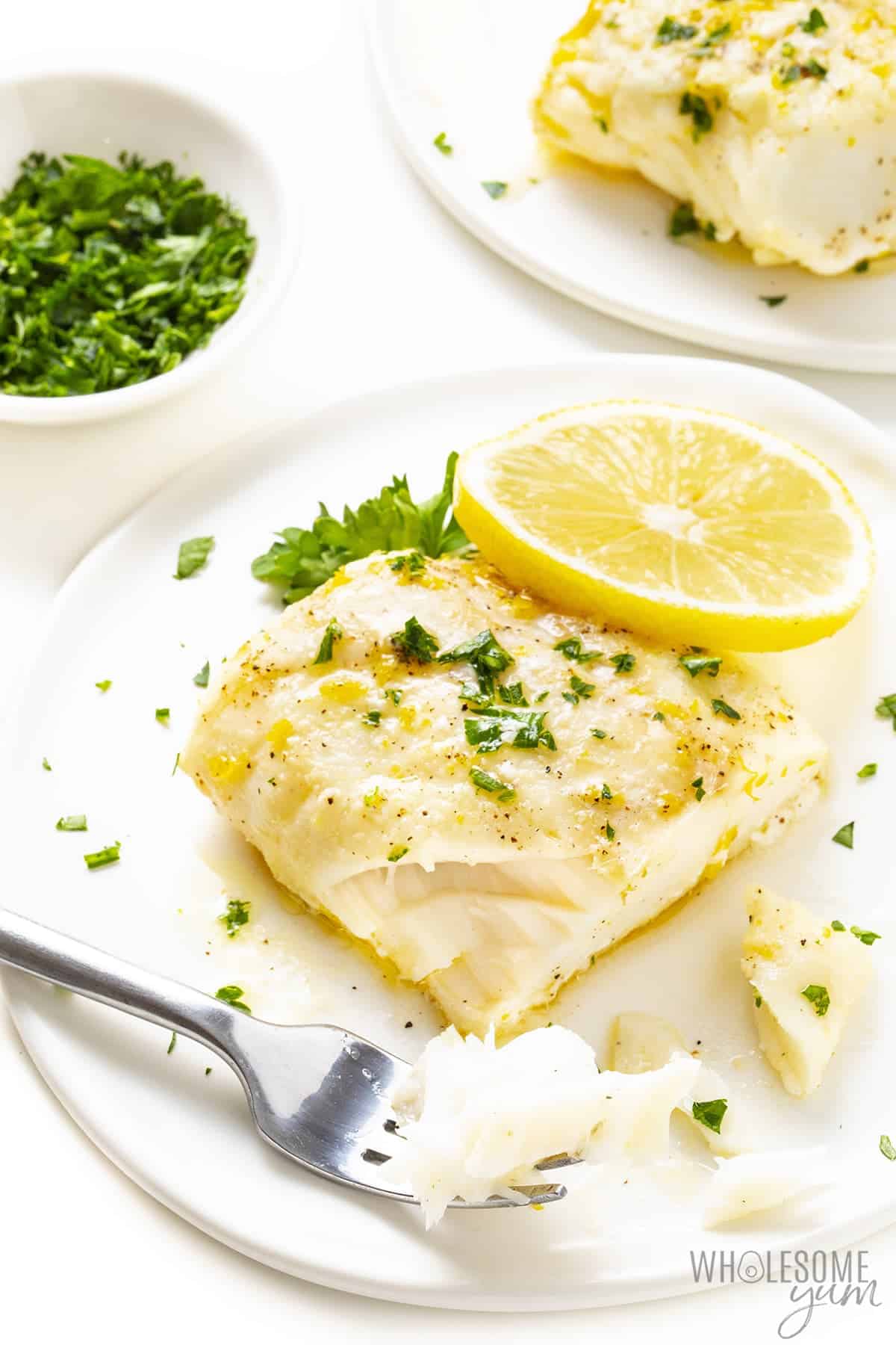 Flaked baked cod on a plate with fork