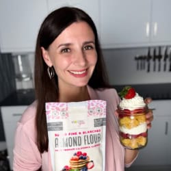 Maya holding strawberry shortcake in a jar and a bag of almond flour.