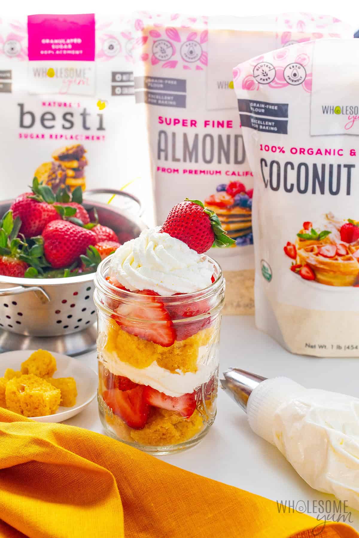 Almond flour strawberry shortcake in a jar next to Wholesome Yum ingredients.